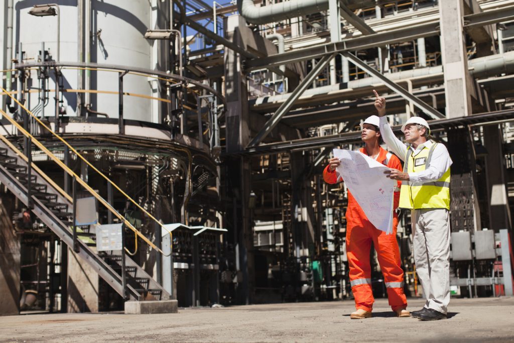 Workers talking at oil refinery